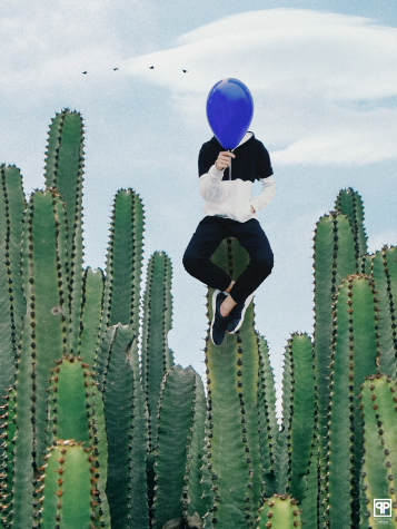 a person holding a balloon surrounded by cactuses